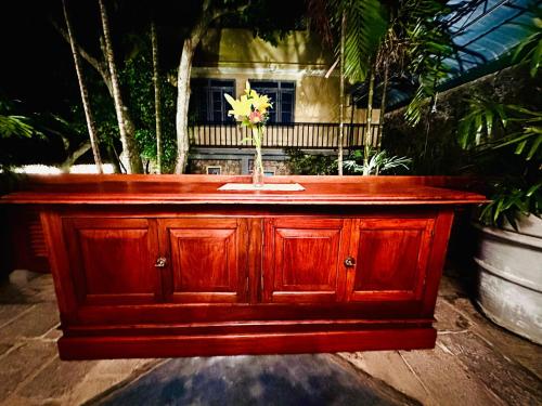 a wooden cabinet with a vase with a flower in it at Colonial Retreat Villa in Talawatugoda