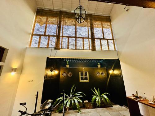 a room with plants and a large window at Colonial Retreat Villa in Talawatugoda