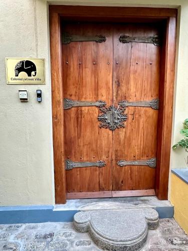 a wooden door with a sign on the side of a building at Colonial Retreat Villa in Talawatugoda