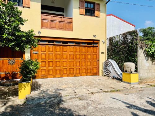 a house with a large wooden garage door at Colonial Retreat Villa in Talawatugoda