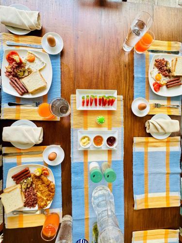 a wooden table with plates of food on it at Colonial Retreat Villa in Talawatugoda