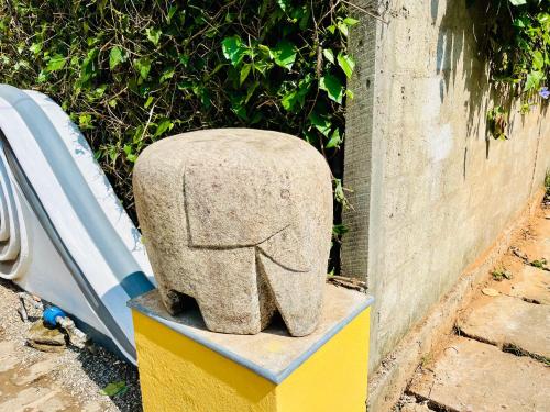 a stone elephant statue sitting next to a wall at Colonial Retreat Villa in Talawatugoda