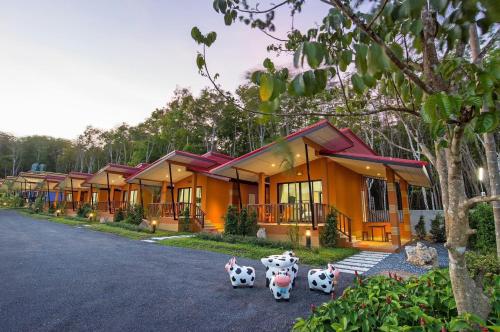 a row of houses with cow statues in front of them at Infinite Resort and Cafe in Krabi