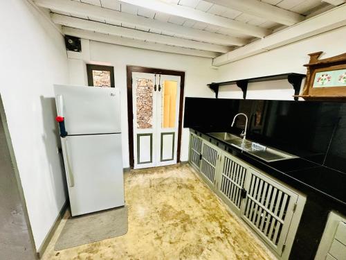 a kitchen with a white refrigerator and a sink at Colonial Retreat Villa in Talawatugoda
