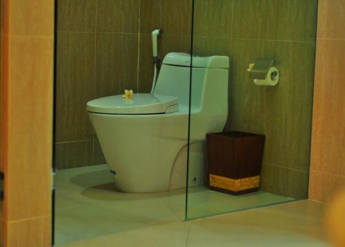 a bathroom with a toilet and a glass wall at Villa Elsa Seaview in Temukus