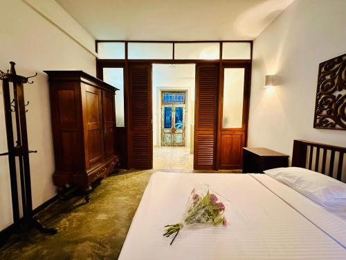 a bedroom with a bed with flowers on it at Colonial Retreat Villa in Talawatugoda