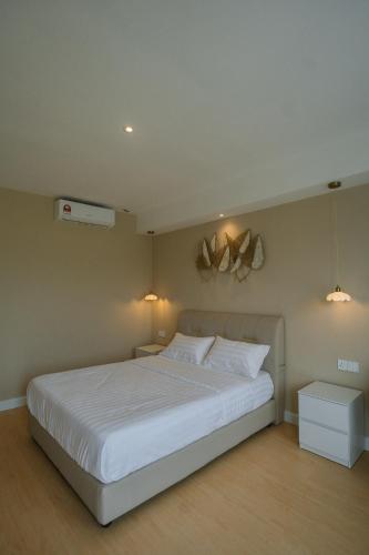 a bedroom with a large white bed with two pillows at White Roses Cottage in Keningau