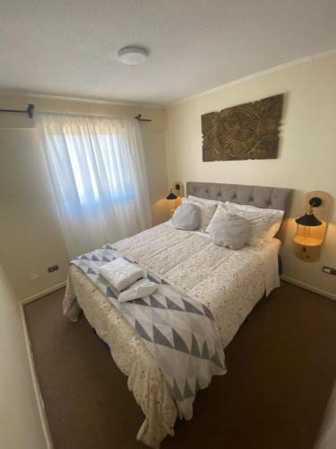 a bedroom with a large bed and a window at Departamento Centro Curicó in Curicó