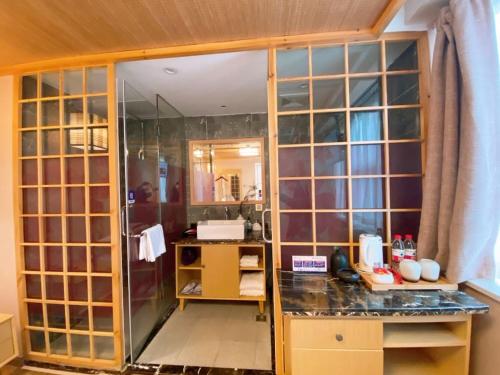 a bathroom with a shower with a glass wall at Fresh House Hotel - West Lake Qingchun Branch in Hangzhou
