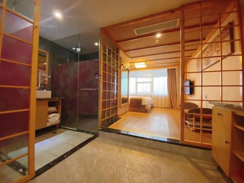 a bathroom with a glass walled shower in a room at Fresh Hours Hotel - West Lake Qingchun in Hangzhou