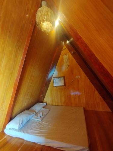 Coolis beach في ماسبات: سرير صغير في غرفة ذات سقف
