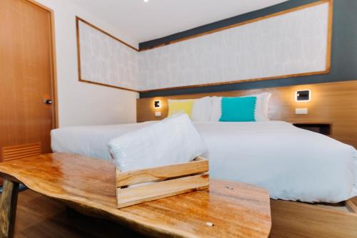 a bedroom with a bed and a wooden table at Jovinaj Travellers Inn in Bula