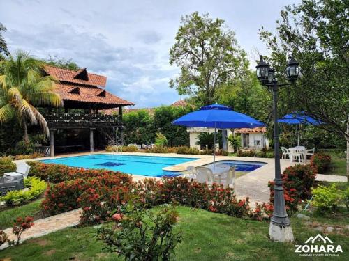 a resort with a swimming pool and a house at Finca Villa Lili in Santa Fe de Antioquia