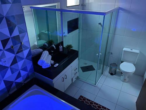 uma casa de banho com um chuveiro, um lavatório e um WC. em Recanto Nova Canaã em Conceição de Jacuípe