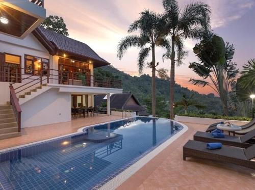 a house with a swimming pool in front of a house at Patonghill estate 6 bedroom sea view in Patong Beach