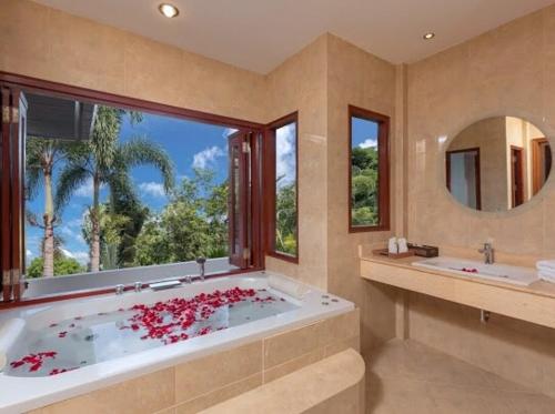 a large bathroom with a tub with red flowers in it at Patonghill estate 6 bedroom sea view in Patong Beach