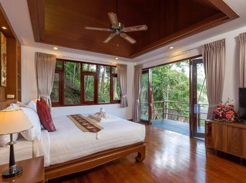a bedroom with a bed with a ceiling fan at Patonghill estate 6 bedroom sea view in Patong Beach