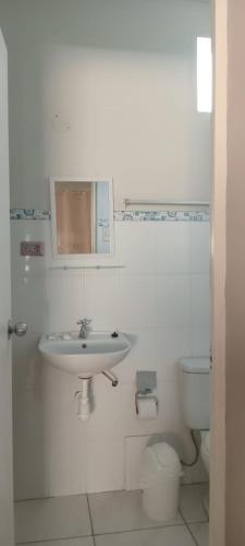 a white bathroom with a sink and a toilet at HospedajesPerú in Zorritos