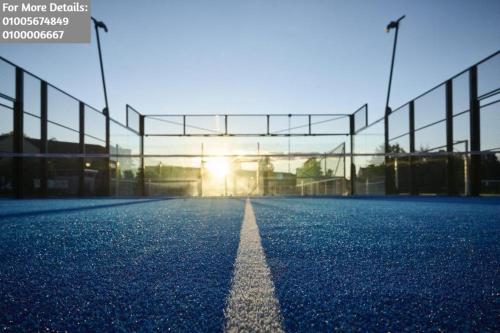 un court de tennis vide avec le soleil en arrière-plan dans l'établissement Porto Said Rental - بورتو سعيد, à `Ezbet Shalabi el-Rûdi