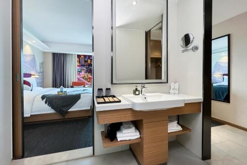 baño con lavabo, cama y espejo en Yizhi Hotel - Guangzhou Zhujiang New City Huashi Metro Station en Guangzhou