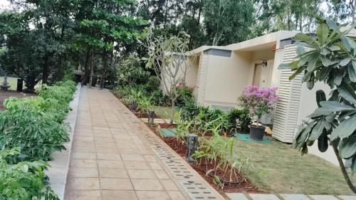 a garden with a walkway in front of a house at Residency Lake Resort & Spa in Mulshi