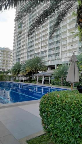 ein großes Apartmenthaus mit Pool und Sonnenschirm in der Unterkunft Modern 2BR Condo with Fiber Net and Netflix in Davao City
