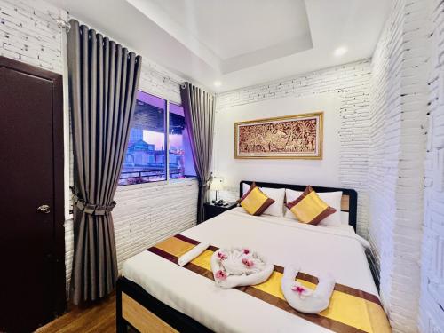 a bedroom with a bed and a window at Sun Chakra Boutique Hotel - 50m to Museum & Royal Palace & Walking street in Phnom Penh