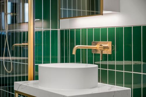 メルボルンにあるMid-Century Modern Hideawayの緑のタイル張りのバスルーム(シンク、蛇口付)