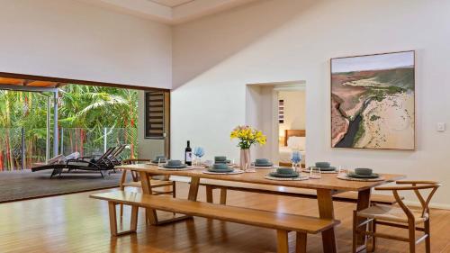 a dining room with a wooden table and chairs at 25 The Lakes Estate Port Douglas in Port Douglas