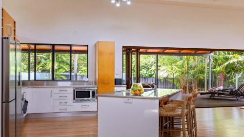 a kitchen with white appliances and a living room at 25 The Lakes Estate Port Douglas in Port Douglas