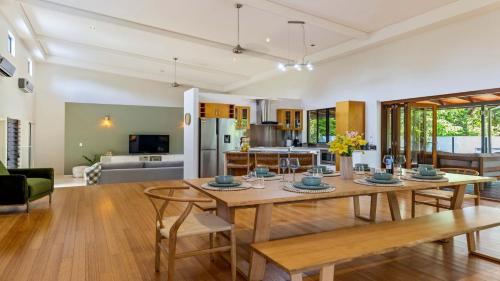 a dining room and living room with a table and chairs at 25 The Lakes Estate Port Douglas in Port Douglas