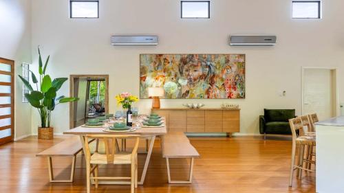 a dining room with a table and a painting on the wall at 25 The Lakes Estate Port Douglas in Port Douglas