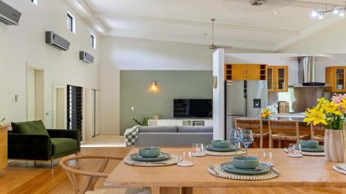 a kitchen and living room with a table and chairs at 25 The Lakes Estate Port Douglas in Port Douglas