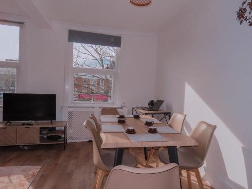 a dining room with a table and chairs and a television at Budget 2BDR apartment 6PPL pets in Teddington