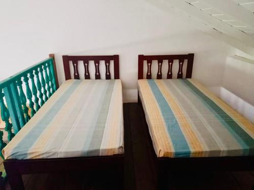 two beds sitting next to each other in a room at Colonial Retreat Villa in Talawatugoda