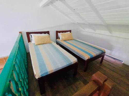 two beds sitting in a room with at Colonial Retreat Villa in Talawatugoda