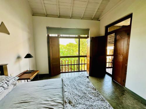a bedroom with a bed and a desk and a window at Colonial Retreat Villa in Talawatugoda