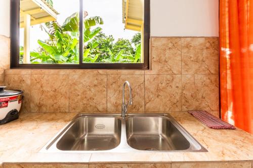 a stainless steel sink in a kitchen with a window at Rio Celeste, Aire Acondicionado, Comodidad in Upala