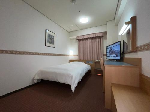 a hotel room with a bed and a flat screen tv at Hotel Alpha-One Izumo in Izumo