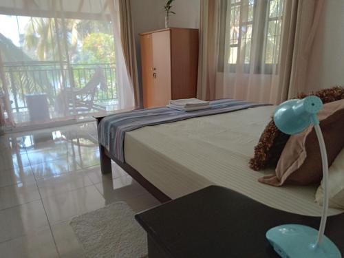 um quarto com uma cama e uma grande janela em Lake Life Villa em Ambalangoda