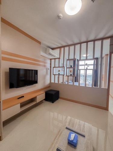 a living room with a flat screen tv on a wall at Formosa Residence Apartment Master #2209 in Jodoh