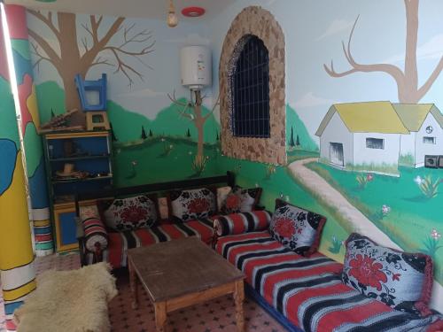 een woonkamer met een muurschildering aan de muur bij Atlase Surf hostel in Taghazout