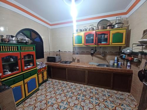 een keuken met kleurrijke kasten en een aanrecht bij Atlase Surf hostel in Taghazout
