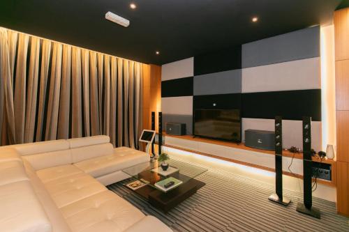 a living room with a white couch and a television at Tanjung Bungah 5BR 18 Bungalow KTV in Tanjung Bungah