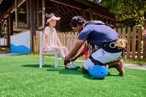 a man playing with a ball with a girl sitting in a chair at Jawakara Islands Maldives in Lhaviyani Atoll