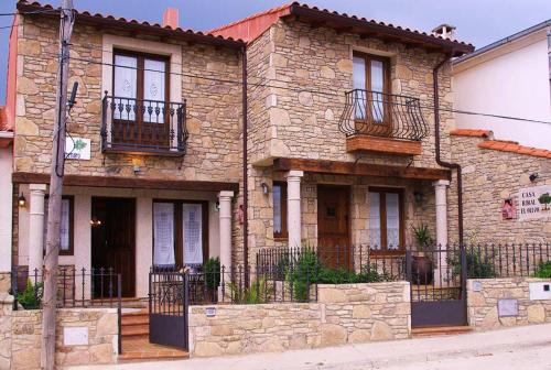 a large stone house with balconies on a street at EL ALMENDRO in Aldeadávila de la Ribera