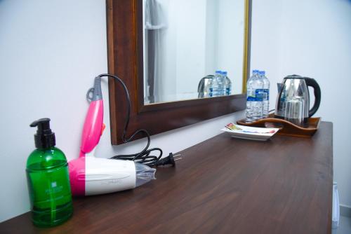 a bathroom counter with a hair dryer and a mirror at Ever Breeze Ella Hotel in Ella