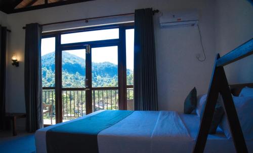 a bedroom with a bed and a large window at Ever Breeze Ella Hotel in Ella