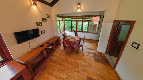 a living room with a table and a flat screen tv at Tea Cottage Resort and Spa in Nawalapitiya