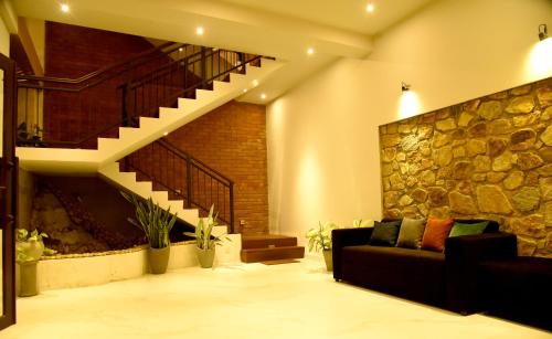 a living room with a couch and a stone wall at Ever Breeze Ella Hotel in Ella